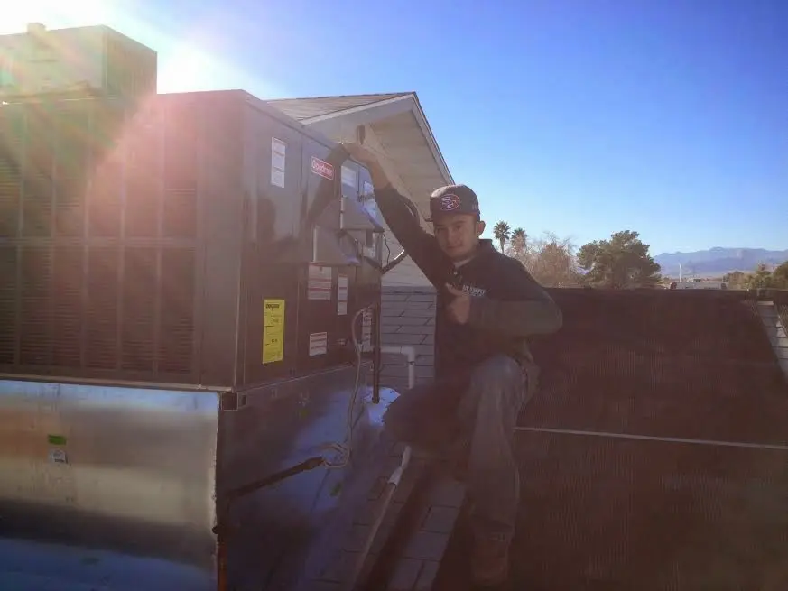 HVAC technician performing AC Tune-Up on a rooftop unit in Moberly